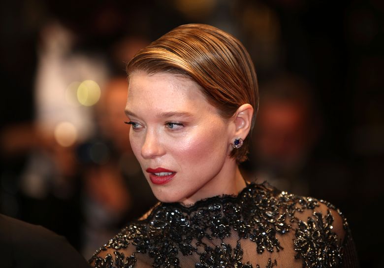 Lea Seydoux wears gold and purple stone pendant earrings, a black News  Photo - Getty Images