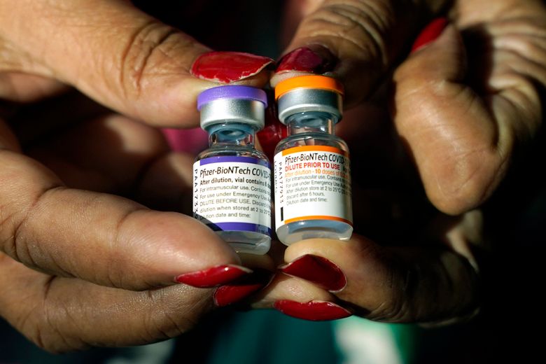 A nurse holds a vial of the Pfizer COVID-19 vaccine for children ages 5 to 11, right, and a vial of the vaccine for adults, which has a different colored label, at a vaccination station in Jackson, Miss., earlier this year. U.S. regulators recommended a COVID-19 booster shot for healthy 5- to 11-year-olds on Tuesday, May 17, 2022, hoping an extra vaccine dose will enhance their protection as infections once again are on the rise. (AP Photo/Rogelio V. Solis, File)