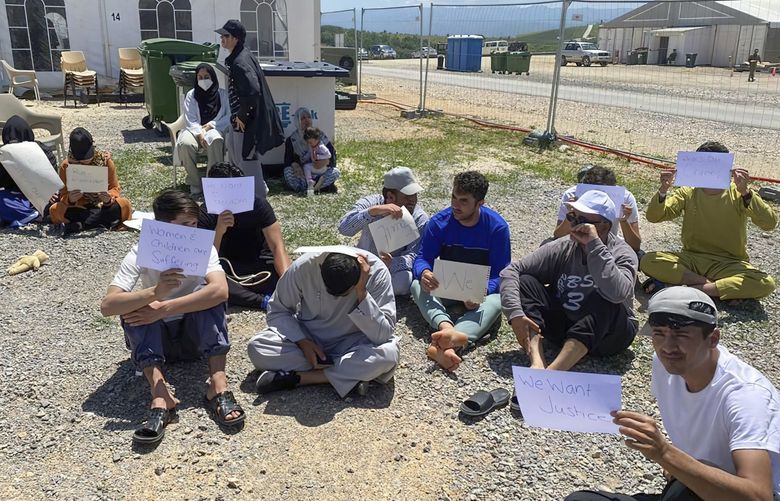 This image provided by Muhammad Arif Sarwari, shows Afghans who fled the Taliban takeover of their country staging a protest at Camp Bondsteel in Kosovo, Wednesday, June 1, 2022. The camp is used to house people who have not been allowed to enter the U.S. because of security concerns. Some of the Afghans have been waiting for months at the base while authorities try to resolve their fate, which officials say may involve sending them to another country for resettlement. (Muhammad Arif Sarwari via AP) WX255 WX255