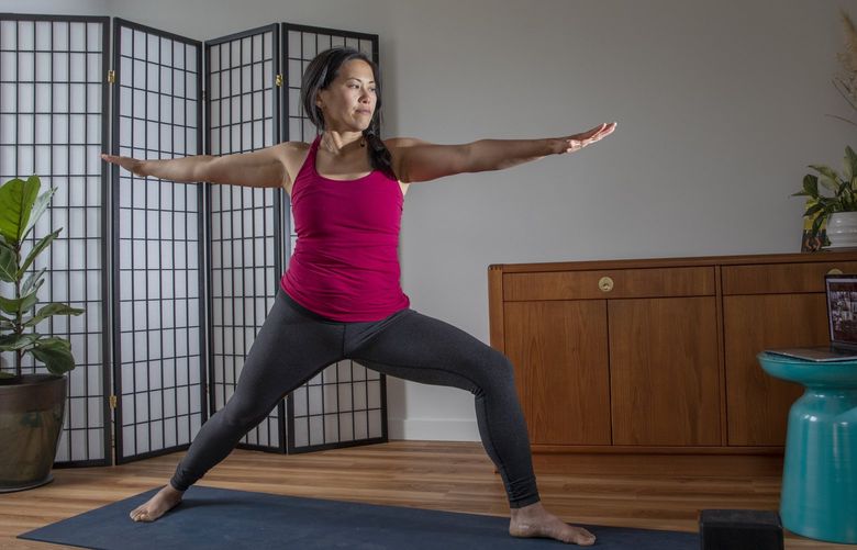 Nicole Tsong joins a yoga zoom class in her Seattle home Thursday, May 20, 2021. 217150