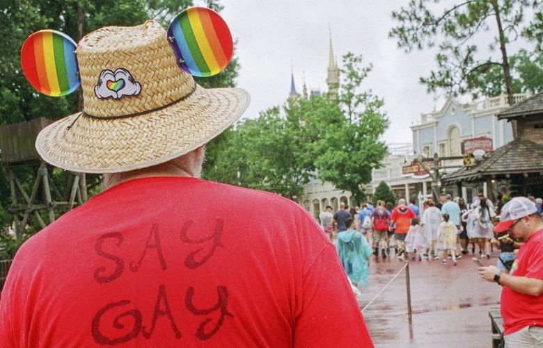 Visitors in red shirts, symbolically important  — especially in its early years — of what is informally known as Gay Days, at Disney World in Lake Buena Vista, Fla., June 4, 2022. The four days annually that started in 1991 with just a smattering of gay adults took on new significance this year, when Disney was ensnared in a heated cultural debate. (Lawren Simmons/The New York Times) XNYT203