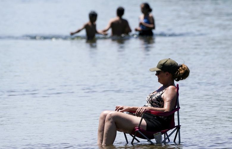 Dianna Andaya, relaxes in the cooling water of the American River as the temperature climbed over the 100 degree mark in Sacramento, Calif., Friday, June 10, 2022. Forecasters are warning of dangerously high temperatures in much of the interior of California as high pressure grips the region. (AP Photo/Rich Pedroncelli) CARP504