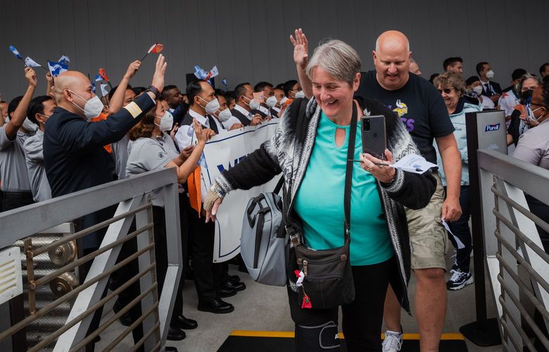 The first passengers to board Holland America’s Westerdam in two years begin walking up the gangplank to the ship as crew members cheer in Seattle, WA on June 12, 2022.