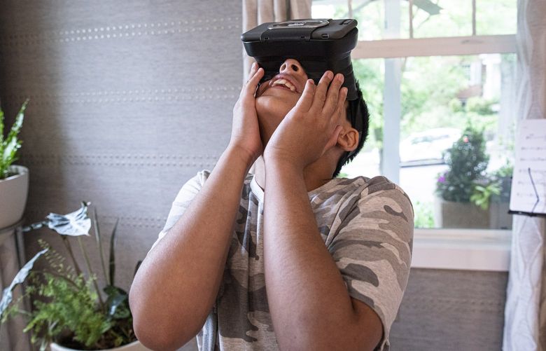 The son of Vijay Ravindran, founder of technology startup Floreo, plays with a VR headset in Washington, on June 11, 2022. Floreo is developing virtual reality lessons designed to help behavioral therapists, speech therapists, special educators, and parents who work with autistic children. (Valerie Plesch/The New York Times)