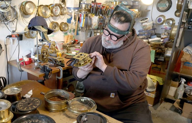 Clock restorer and repairer Michael Short has been bringing life back to vintage clocks for more than 30 years.
His shop is in his garage near Shelton, Wa. He specializes in ships bell clocks made by Chelsea and Seth Thomas.  Chelsea, founded in 1897,  is still in business in Chelsea, Mass. Chelsea is considered  the last great US clock maker. 
Heâ€™s examining an early 1900â€™s Seth Thomas ships bell clock with a broken spring.
 220641
