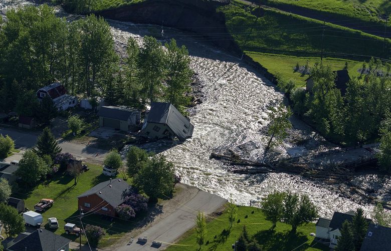 A house sits in Rock Creek after floodwaters washed away a road and a bridge in Red Lodge, Mont., in Red Lodge, Mont., Thursday, June 16, 2022. (AP Photo/David Goldman) MTDG111 MTDG111