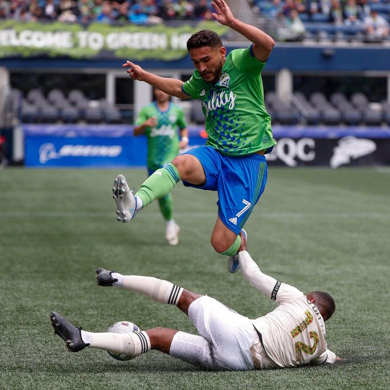 Los Angeles FC defender Diego Palacios, bottom,  tackles the ball away from Sounders FC midfielder Cristian Roldan during the first half Saturday, June 18, 2022, in Seattle.  (Jennifer Buchanan / The Seattle Times)