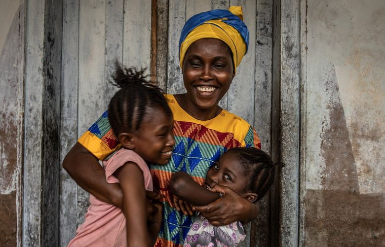— EMBARGO: NO ELECTRONIC DISTRIBUTION, WEB POSTING OR STREET SALES BEFORE 3:01 A.M. ET ON TUESDAY, JUNE 14, 2022. NO EXCEPTIONS FOR ANY REASONS — Kadiatu Bangura, with daughters Adama, left, and Mariama, in Port Loko, Feb. 20, 2022. Bangura stopped performing genital excisions at the urging of her eldest daughter, Zeinab.  (Finbarr O’Reilly/The New York Times) XNYT XNYT