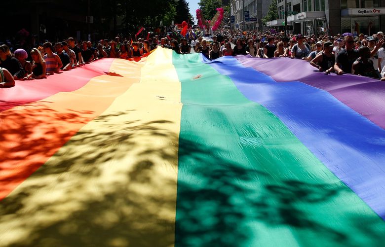 Paradegoes help carry the rainbow flag during the The 42nd annual Seattle Pride Parade on June 26, 2016.