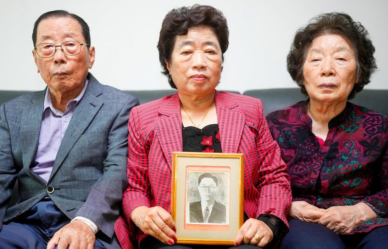 Choi Byung-hee holds the only picture she has of her father, abducted by North Korea, with her father’s siblings: Choi Cha-moon, 86, left, and Choi Tae-boon, 79, in Seoul, South Korea, on June 16, 2022. Families whose relatives have been abducted or imprisoned by North Korea are seeking to hold the country financially accountable despite the long odds of collecting money from the isolated nation. (Chang W. Lee/The New York Times) XNYT28