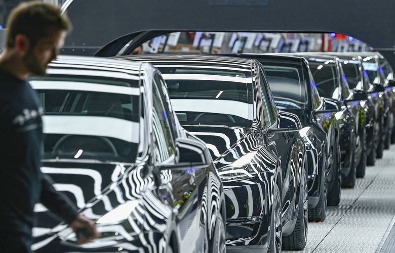 Model Y electric vehicles stand on a conveyor belt at the opening of the Tesla factory in Berlin Brandenburg in Gruenheide, Germany, Tuesday, March 22, 2022. The first European factory in Gruenheide, designed for 500,000 vehicles per year, is an important pillar of Tesla’s future strategy. (Patrick Pleul/Pool via AP) DMME153