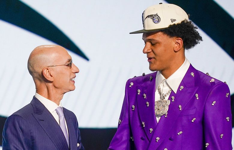 Paolo Banchero, right, is congratulated by NBA Commissioner Adam Silver after being selected as the number one pick overall by the Orlando Magic in the NBA basketball draft, Thursday, June 23, 2022, in New York. (AP Photo/John Minchillo) NYJJ116