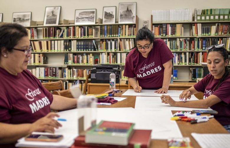 Angie Villescaz, Adela Garza-Bond and Angeli Gomez make protest signs at El Progreso Memorial Library on Monday in Uvalde, Texas.
