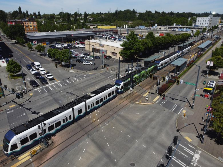 A southbound light-rail train running along Martin Luther King, Jr. Way South travels through two crosswalks at the south end of the Othello station. (Ken Lambert / The Seattle Times)