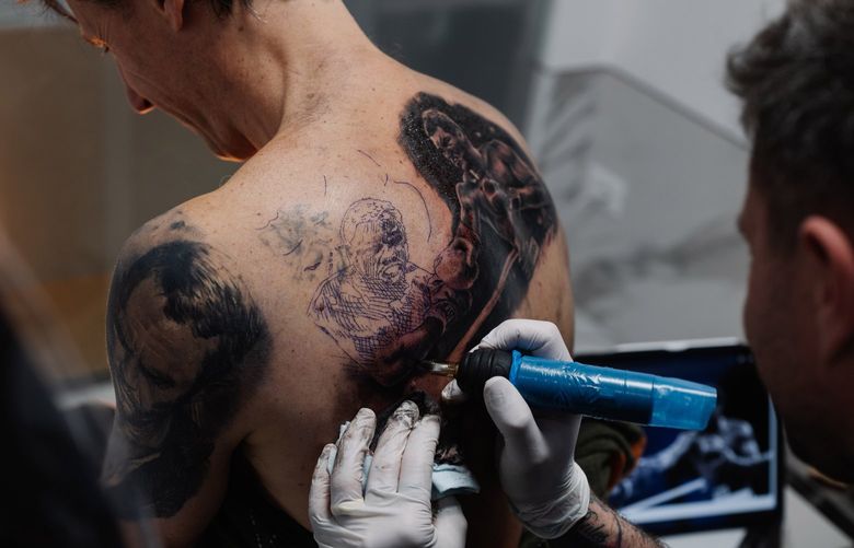 The tattoo artist Alex De Pase works on a customer at his home studio in the village of Grado, Italy, April 7, 2022. New regulations on tattoo inks, meant to reduce the risk of ingredients potentially hazardous to humans, have artists and manufacturers struggling to find replacements. (Ciril Jazbec/The New York Times)