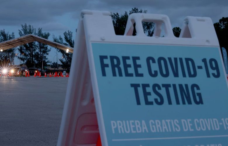 Health care workers at a 24-hour drive-thru site set up by Miami-Dade and Nomi Health in Tropical Park administer COVID-19 tests on Aug. 30, 2021, in Miami. (Joe Raedle/Getty Images/TNS) 51766400W 51766400W