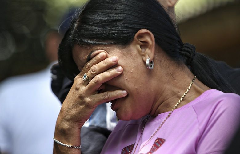 A woman cries as she waits for news of inmates after a deadly prison fire in Tulua, Colombia, Tuesday, June 28, 2022. Authorities say at least 51 people were killed after the fire broke out during what appeared to be an attempted riot early Tuesday. (AP Photo/Andres Quintero) XRM125 XRM125
