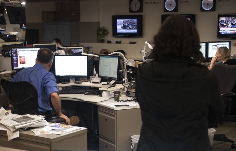 In this Feb. 5, 2020, photo Associated Press Washington Bureau Chief Julie Pace, standing right, listens in the newsroom at the Associated Press in Washington. (AP Photo/Jenny Kane)