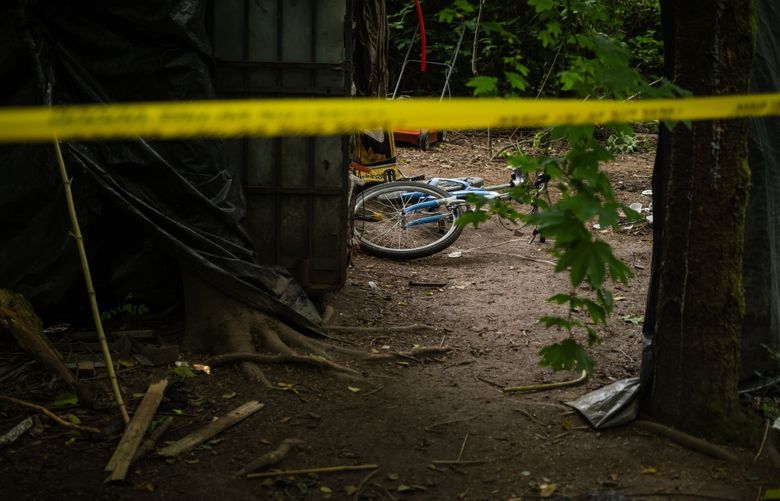 Police caution tape cordons off an area at a homeless encampment in West Seattle where a man was fatally shot last week. (Kori Suzuki / The Seattle Times)