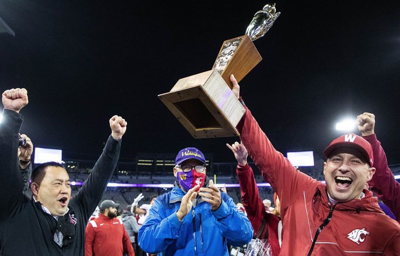 Coach Jake Dickert, right, and Athletic Director Pat Chun, left, join Governor Jay Inslee in the Apple Cup trophy presentation.
.
The Washington State Cougars played the Washington Huskies in Pac-12 football Friday, Nov 26, 2021, in the annual Apple Cup game from Husky Stadium, in Seattle, WA. 218875
