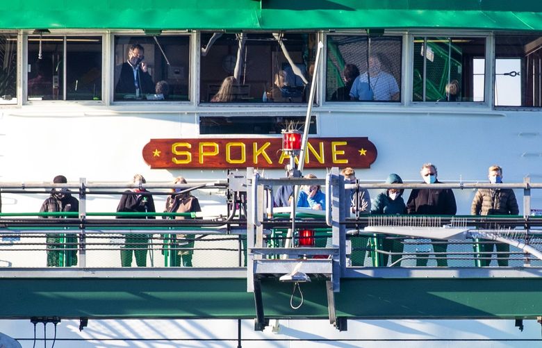 Stranded passengers on the M/V Spokane ferry watch as logs, spilled from a log-truck are removed from the front fo the ferry on Monday. Eighty cars and their passengers had to wait several hours before they could drive off the ferry on December 28, 2020.  216012