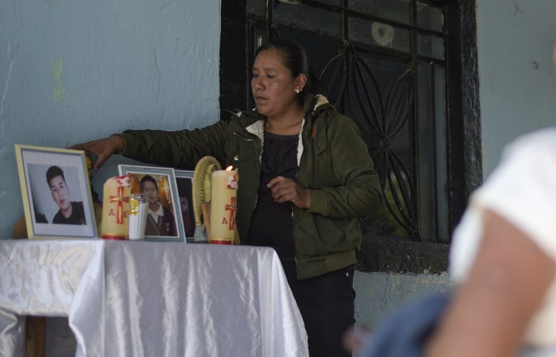 Yolanda Olivares, mother of Yovani and Jair Valencia Olivares, arranges an altar with the photographs of her missing children, in front of her home in San Marcos Atexquilapan, Veracruz state, Mexico, Thursday, June 30, 2022. Neighbors prayed for the youths who are missing after confirming that they were traveling in the abandoned trailer in San Antonio, Texas, where more than 50 bodies of migrants were found. (AP Photo/Yerania Rolon) MXEV101 MXEV101