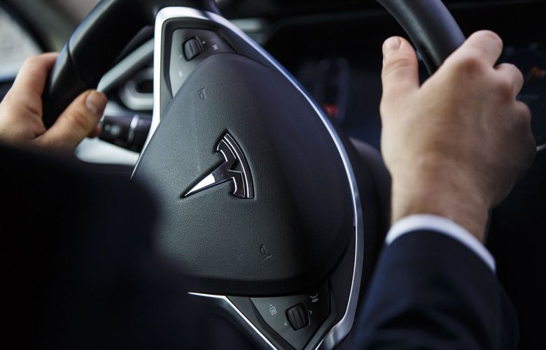 The Tesla logo on the steering wheel of an Uber Tesla Model S electric automobile.