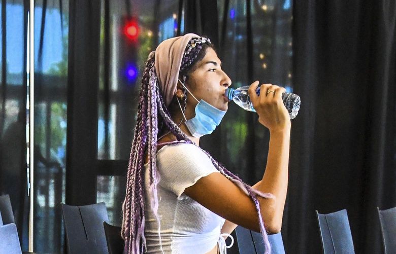 As the temperatures climb into the 90s, “Indigo,” age 24, takes a drink of water while beating the heat in the cooling center located at the Looff Carousel, Saturday, June 26, 2021 in Riverfront Park in Spokane, Wash.
(Dan Pelle/The Spokesman-Review via AP) WASPO105 WASPO105