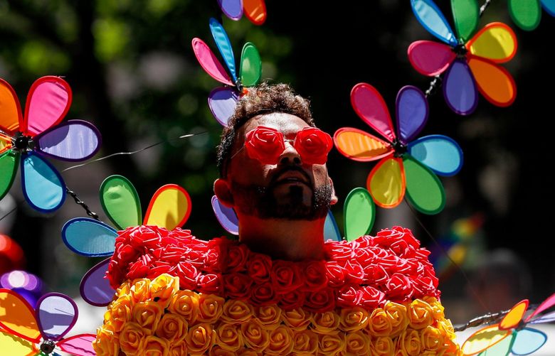 Downtown Seattle – Seattle Pride Parade – 062622
A performer with Entre Hermanos looks up into the sun with rose shaped sunglasses during the Pride Parade Sunday, June 26, 2022 in Seattle, Wash. 220748