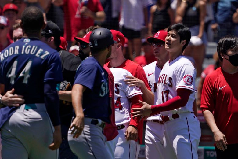 Seattle Mariners’ Julio Rodriguez (44) is held back as Los Angeles Angels’ Shohei Ohtani (17) watches while several members of the Mariners and the Angels scuffle after Mariners’ Jesse Winker was hit by a pitch during the second inning of a baseball game Sunday, June 26, 2022, in Anaheim, Calif. (AP Photo/Mark J. Terrill)