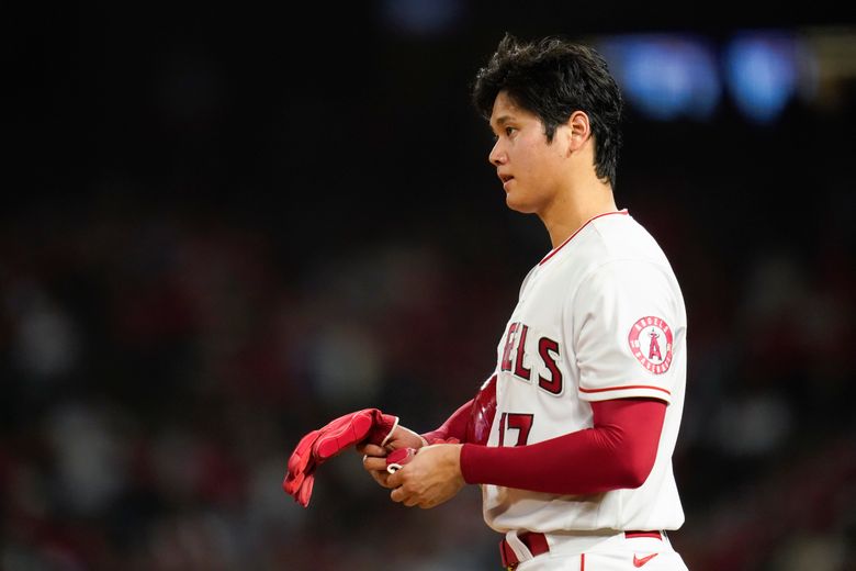 Shohei Ohtani of the Los Angeles Angels looks at an iPad in the in 2023