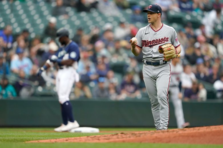 Minnesota Twins starting pitcher Sonny Gray, right, holds the baseball after Seattle Mariners’ Taylor Trammell, left, reached third base after hitting a double and an outfield throwing error during the third inning of a baseball game, Wednesday, June 15, 2022, in Seattle. (AP Photo/Ted S. Warren)