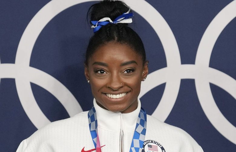 FILE – Simone Biles, of the United States, poses wearing her bronze medal from balance beam competition during artistic gymnastics at the 2020 Summer Olympics, Aug. 3, 2021, in Tokyo, Japan.  President Joe Biden will present the nationâ€™s highest civilian honor, the Presidential Medal of Freedom, to 17 people, at the White House next week. (AP Photo/Natacha Pisarenko, File) WX106 WX106