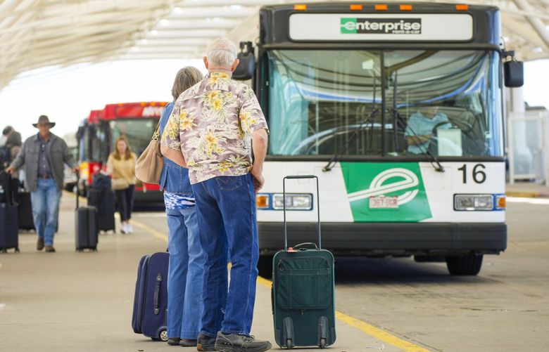 Travelers queue up on the island for shuttle buses to rental car agencies outside the main terminal of Denver International Airport Thursday, May 26, 2022, in Denver. Experts are expecting a flush of travelers at airports and on the nation’s byways during the long Memorial Day weekend, which marks the start of the summer travel season, in spite of high fuel costs. (AP Photo/David Zalubowski) CODZ101