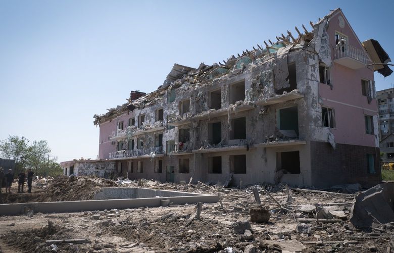 Local officials stand in front of a damaged residential building in the town of Serhiivka, located about 50 kilometers (31 miles) southwest of Odesa, Ukraine, Saturday, July 2, 2022. A Russian airstrike on residential areas killed at least 21 people early Friday near the Ukrainian port of Odesa, authorities reported, a day after the withdrawal of Moscow’s forces from an island in the Black Sea had seemed to ease the threat to the city. (AP Photo/Maxim Penko) XSG129 XSG129