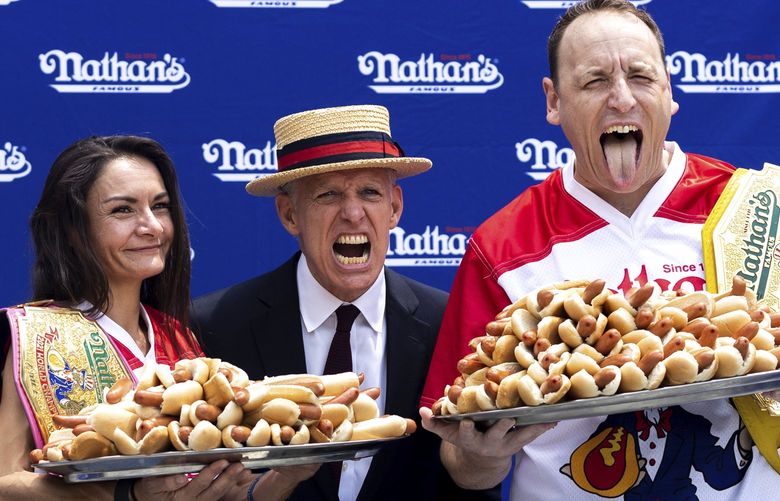 Competitive eaters Michelle Lesco and Joey Chestnut pose for photos with their record number of hot dogs eaten at a weigh-in before the Nathan’s Famous July Fourth hot dog eating contest, Friday, July 1, 2022, in New York. (AP Photo/Julia Nikhinson) NYJN123 NYJN123