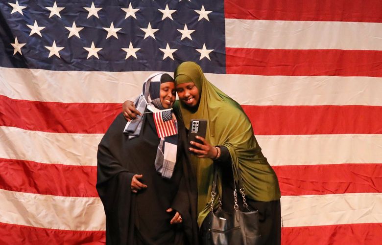 New citizen Badra Hirsi from Somalia photographer herself and her cousin Hodo Mohamed in front of the giant Stars & Stripes in the Seattle Center Armory.  At the 37th Naturalization Ceremony at Seattle Center 293 from 74 countries became citizens.  Her cousin is already a citizen.

Ref to more photos online

With 293 new citizens from 74 countries (CQ)

Monday, July 4 2022 220889