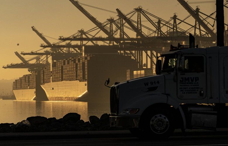 FILE – A truck arrives to pick up a shipping container near vessels moored at Maersk APM Terminals Pacific at the Port of Los Angeles, on Nov. 30, 2021. (AP Photo/Damian Dovarganes, File) 