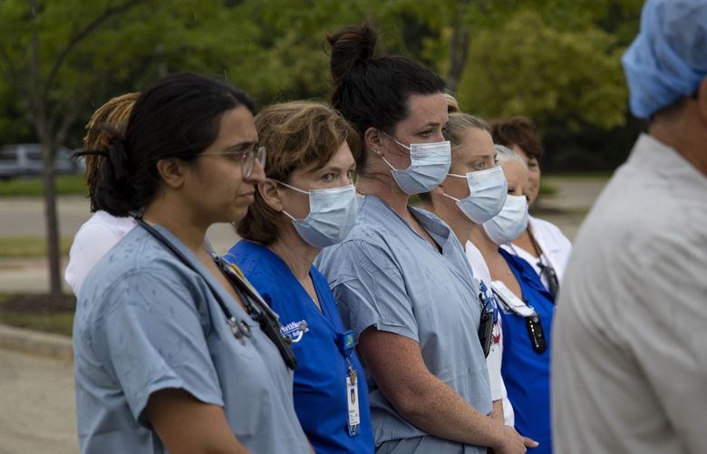 Medical workers step outside NorthShore Highland Park Hospital to brief the media on their treatment of mass shooting victims Monday, July 4, 2022, in Highland Park. (Brian Cassella/Chicago Tribune/TNS) 52297196W 52297196W