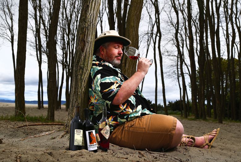 On his fantasy “island” (at Golden Gardens in North Seattle), wine columnist Andy Perdue contemplates the wines he’d like to have if he were stranded. (John Lok / The Seattle Times, 2014) 