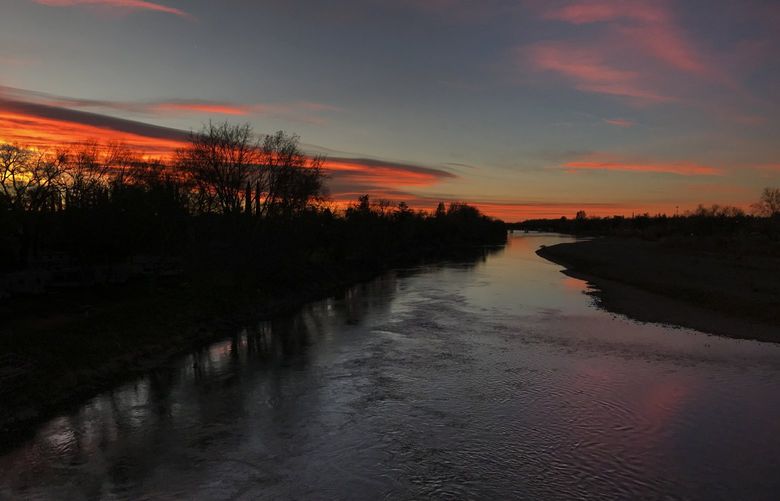 The predawn glow is reflected in the Sacramento River in Red Bluff, California, on Jan. 22, 2022. (Allen J. Schaben/Los Angeles Times/TNS) 52558793W 52558793W
