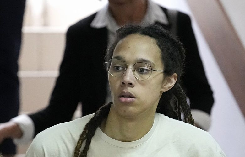 FILE – WNBA star and two-time Olympic gold medalist Brittney Griner is escorted to a courtroom for a hearing, in Khimki, just outside Moscow, Russia, July 1, 2022. Jailed American basketball star Brittney Griner returns to a Russian court Thursday July 7, 2022, as calls increase for Washington to do more to secure her release. Griner was detained in February at a Moscow airport after vape canisters with cannabis oil allegedly were found in her luggage. (AP Photo/Alexander Zemlianichenko, File) LBJ504 LBJ504