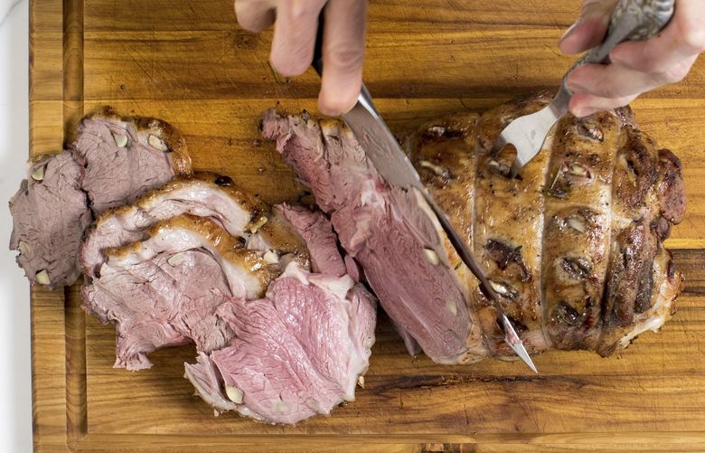 A lamb roast is carved in New York, March 2019. This showstopping dish is packed with garlic and herby flavor, appropriate for any time you want an impressive main course. (Andrew Scrivani/The New York Times) XNYT56 XNYT56