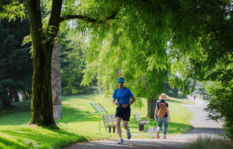 Joggers run through Centennial Park along Elliott Bay Trail in Seattle on July 5, 2022.