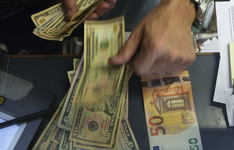A cashier changes a 50 Euro banknote with US dollars at an exchange counter in Rome, Wednesday, July 13, 2022. The euro on Tuesday fell to parity with the dollar for the first time in nearly 20 years. (AP Photo/Gregorio Borgia) 
