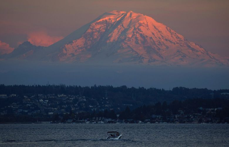 Mount Rainier, illuminated by the last of the sunset, is pictured from Seward Park in Seattle on July 12, 2022.