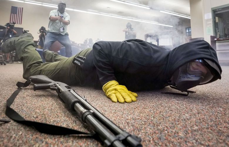 Taylor County sheriff’s deputy Brad Gailey falls to the ground as he portrays an active shooter while pursued by two school marshals during a school safety training demonstration in Round Rock. Officials from Texas Commission on Law Enforcement say more districts are inquiring about the program that allows teachers and school staff to carry guns on campus. (Smiley N. Pool/The Dallas Morning News/TNS) 53373425W 53373425W