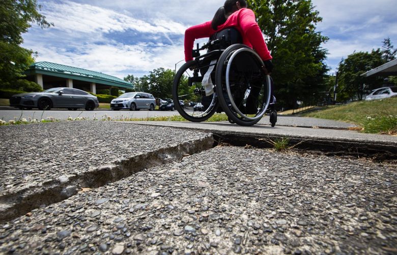 Krystal Monteros, president of the Tacoma Area Commission on Disabilities, heads home after giving a tour of spots where she has struggled with Tacoma’s sidewalks enroute to church or her bus stop, Tuesday, July, 5, 2022.