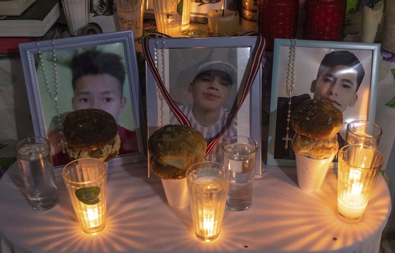 FILE – Photos of Jair Valencia, left, Misael Olivares, center, and Yovani Valencia are displayed on an altar at their home in San Marcos Atexquilapan, Veracruz state, Mexico, on July 13, 2022. The three were among a group of migrants who died of heat and dehydration in a locked tractor-trailer abandoned by smugglers on the outskirts of San Antonio on June 27.  Officials said two men were indicted Wednesday, July 20 in the case.  (AP Photo/Felix Marquez, File) NYAB312 NYAB312