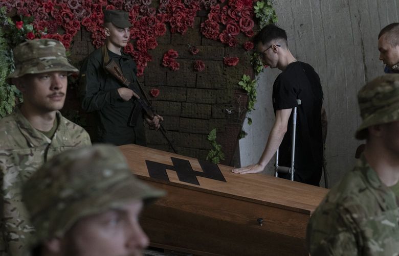 Soldiers of the Azov regiment pay their last respects to a serviceman killed in battle against Russian troops, in a city crematorium in Kyiv, Ukraine, Thursday, July 21, 2022. (AP Photo/Andrew Kravchenko) UAF103 UAF103
